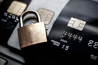 Dettaglio di uno smartphone che effettua un pagamento digitale sicuro tramite carta di credito con un lucchetto di protezione in evidenza.